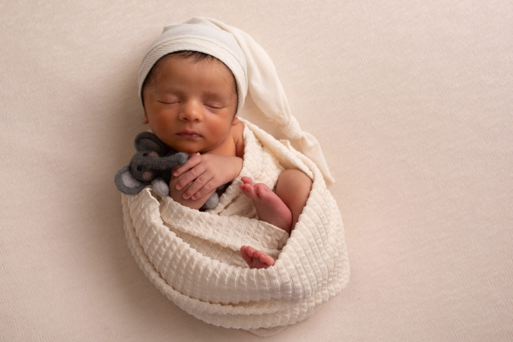 Janesville, Wisconsin newborn photography baby boy against cream background