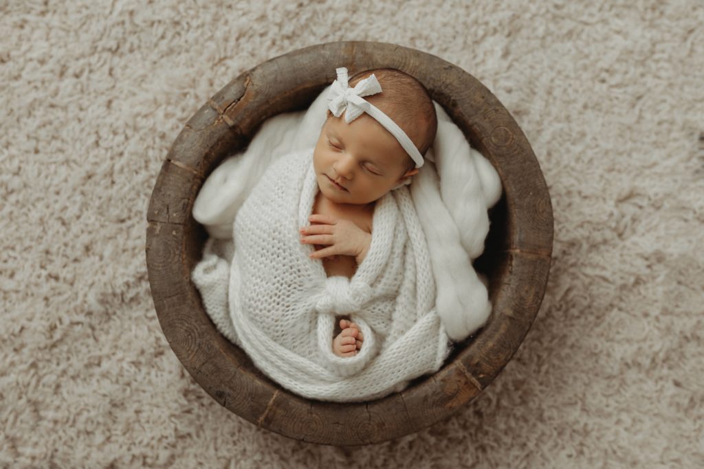 Baby girl in bowl newborn photo shoot