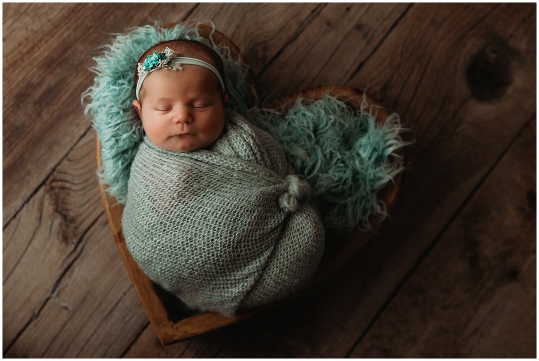 baby girl in heart prop by newborn photographer in Janesville