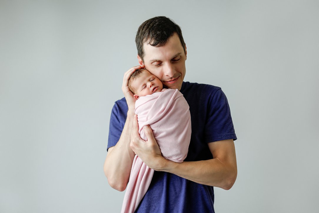 Baby and dad in studio during newborn session by Olivia Acton Photography
