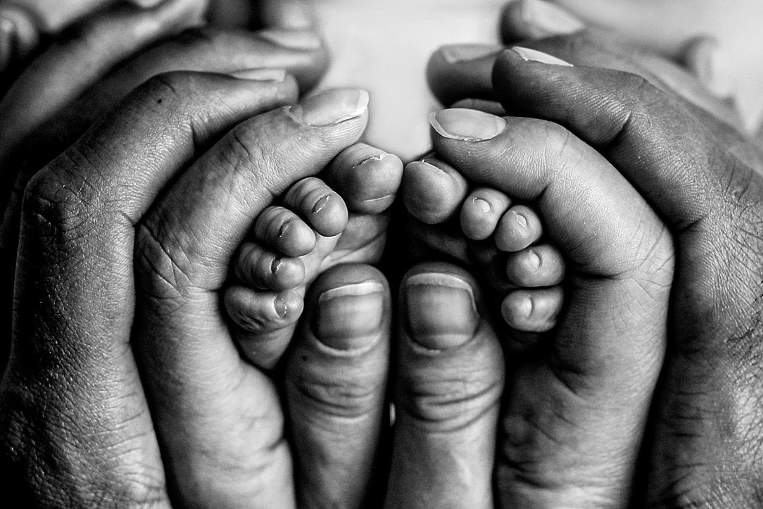 Mom and dad hands with baby in black and white by Olivia Acton Photography