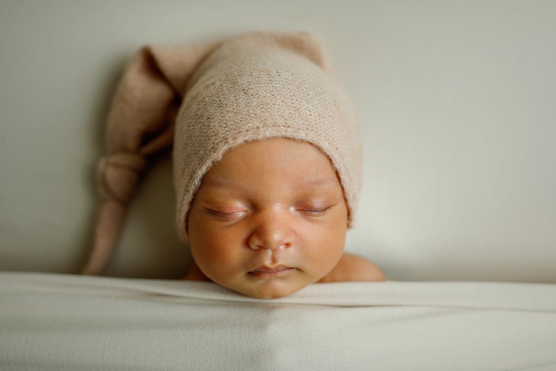 Baby boy in neutrals sleeping during newborn session in Janesville, WI by Olivia Acton