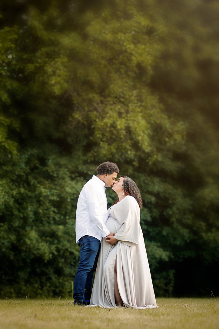 Couple at maternity session kissing outdoors in Janesville, WI by Olivia Acton