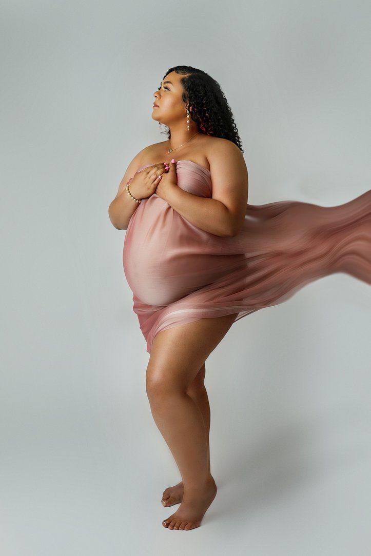 expecting mom at maternity session in pink fabric by Olivia Acton Photography