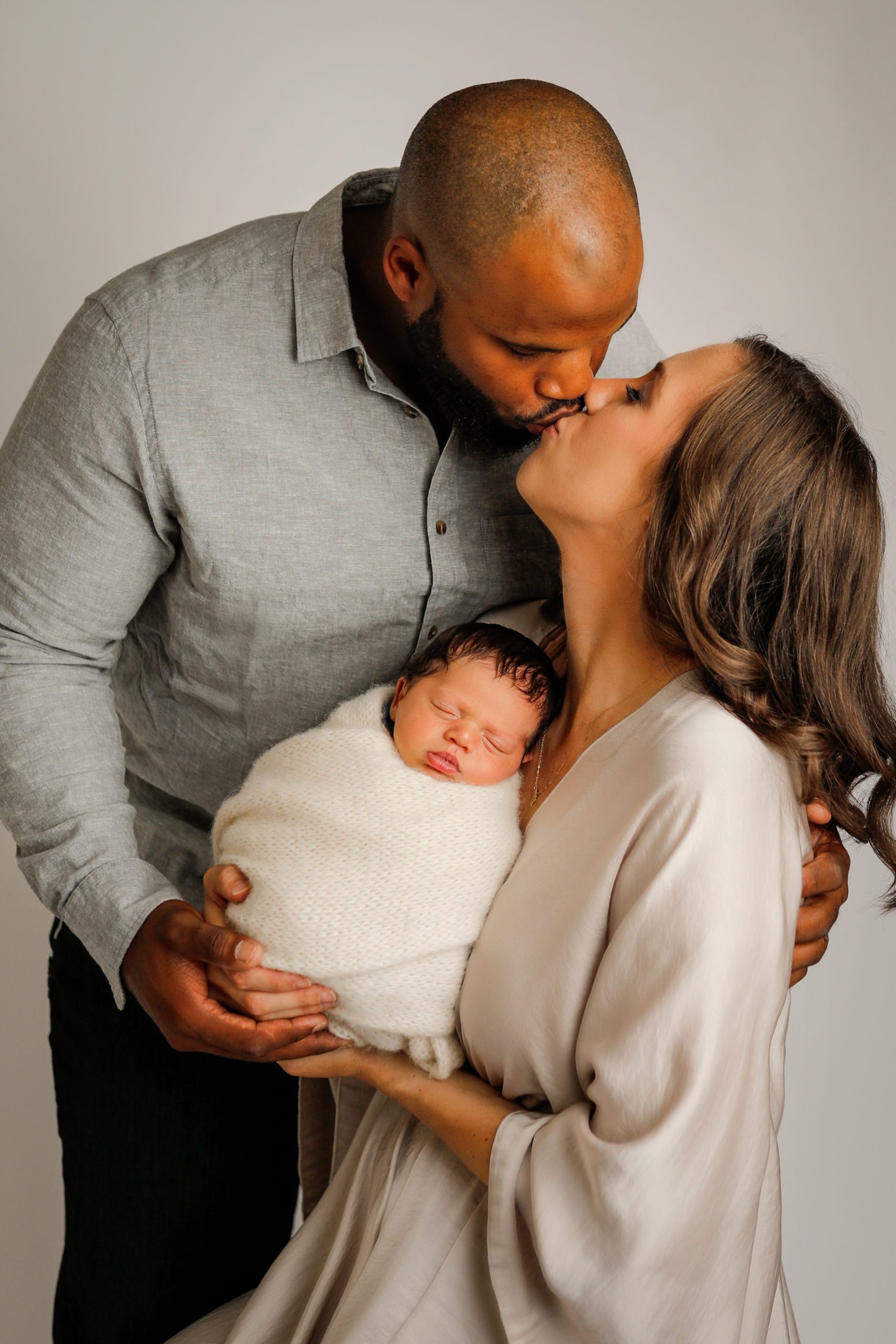 Baby cuddling with dad and  mom during newborn session in Janesville, WI by Olivia Acton Photography