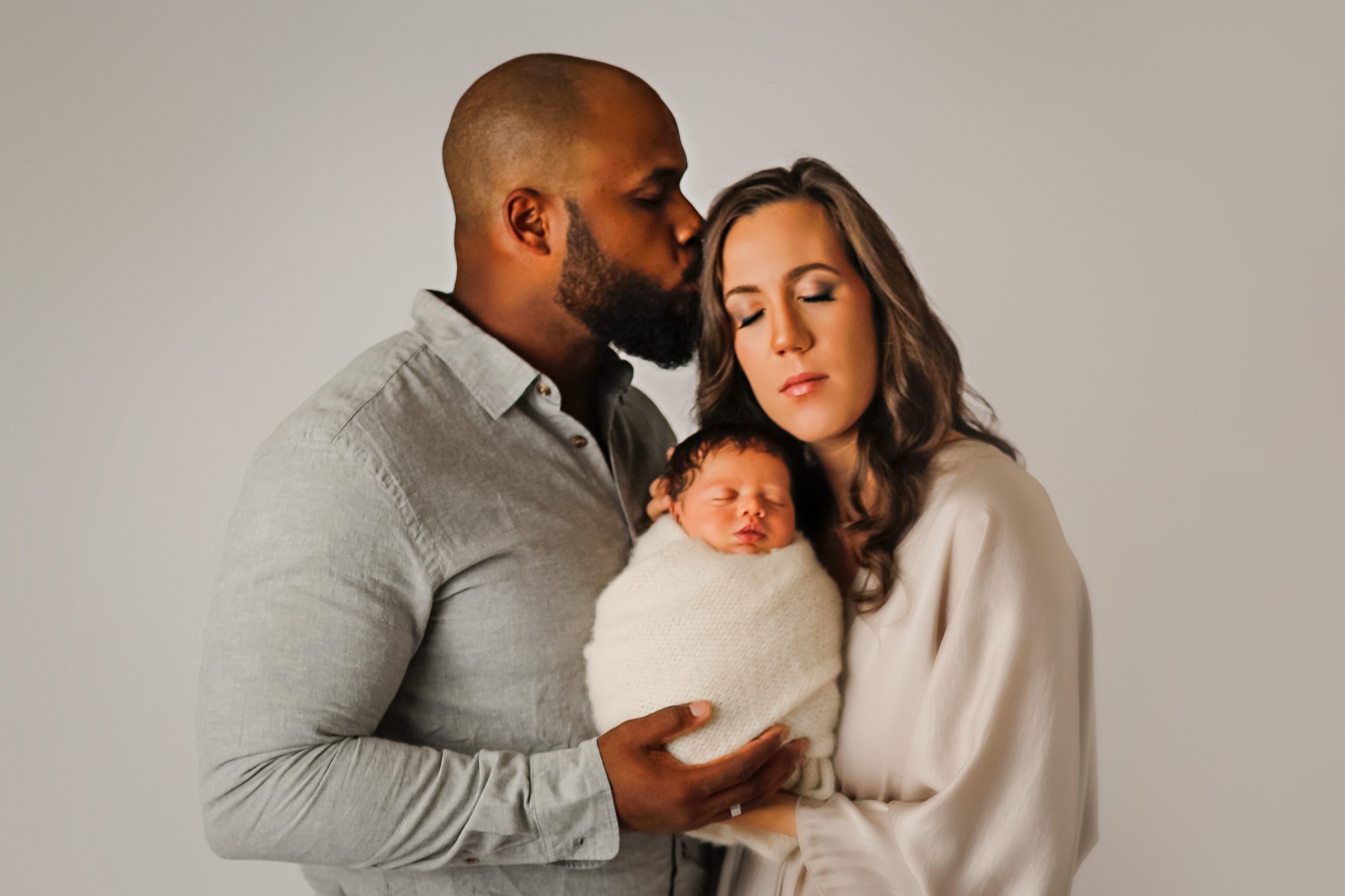 Baby with mom and dad  during newborn session in Janesville, WI 